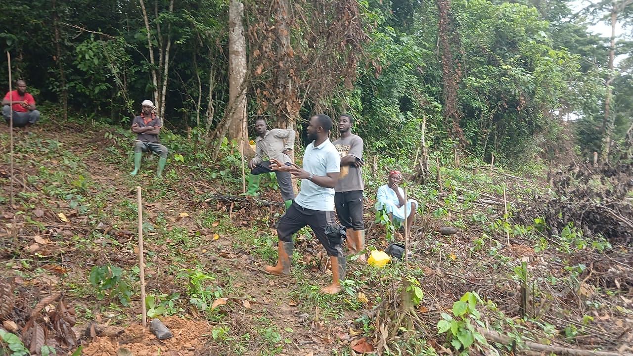 Gadak team member explaining a planting layout to farmers on a pegged plot